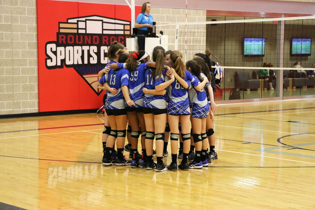 Volleyball players in a huddle at the Round Rock Sports Center