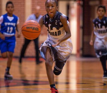 Teen basketball player dribbling on court