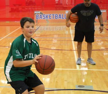 coach and teen on basketball court