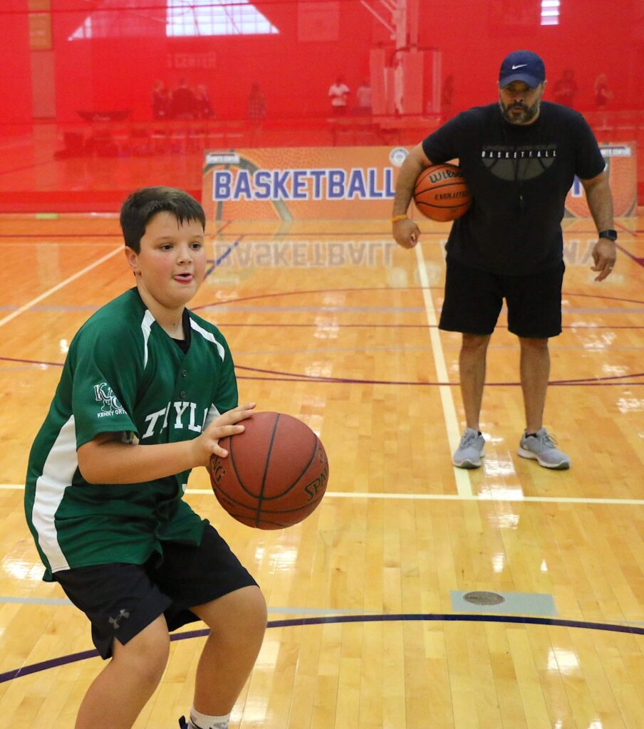 coach and teen on basketball court