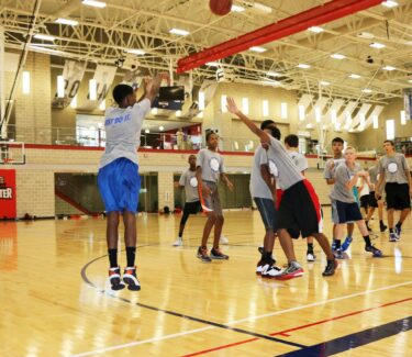 Teens shooting basketball