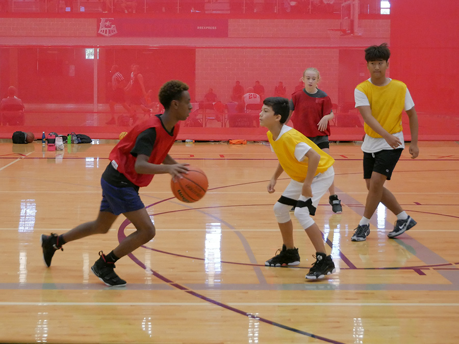 Teens playing basketball on court