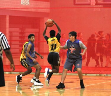 boys playing basketball on court