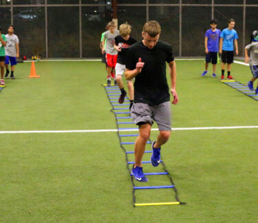 Strength & Conditioning drills with athletes running ladders