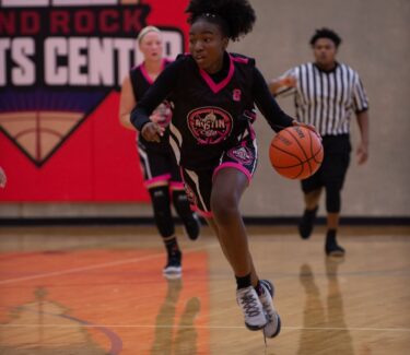 Girl basketball player dribbling ball