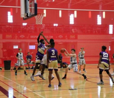Teens playing basketball on indoor court