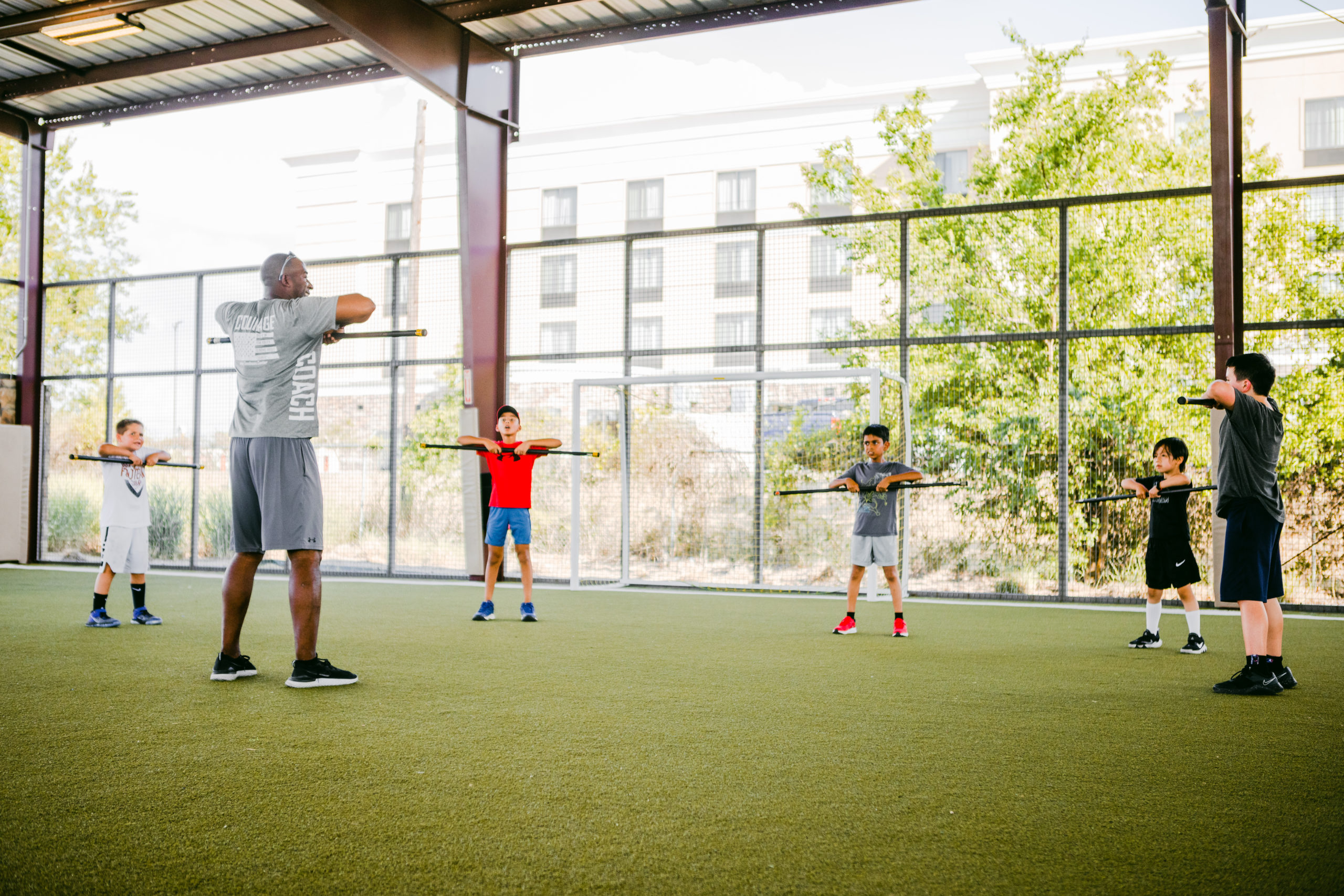 A coach teaching a fitness drill to children at the Round Rock Sports Center
