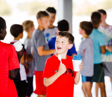 A camper enjoying a blue snow cone at the Round Rock Multipurpose Complex