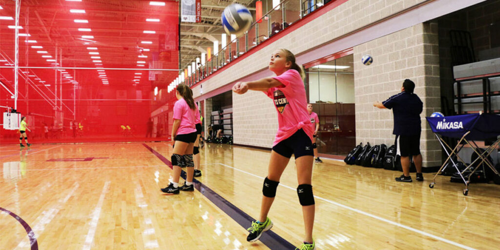 Girl hitting volleyball on court